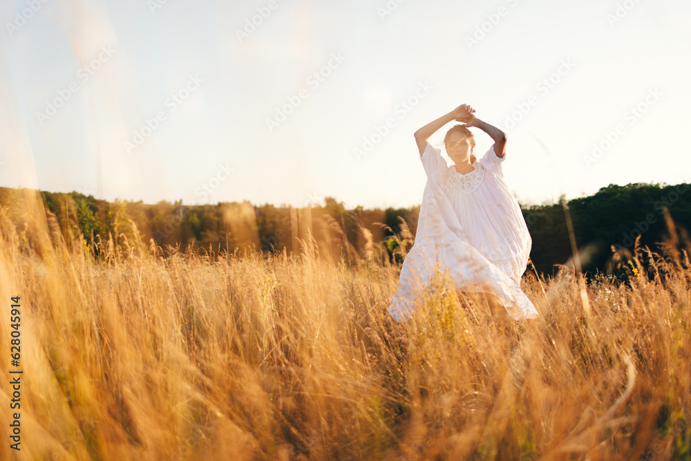 Brunette young woman in wild field. Natural beauty and romance concept. Sunset light.