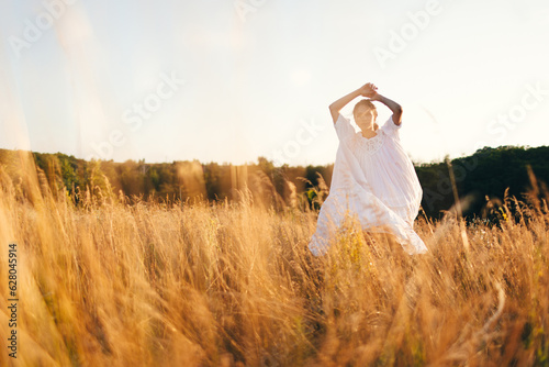 Brunette young woman in wild field. Natural beauty and romance concept. Sunset light.