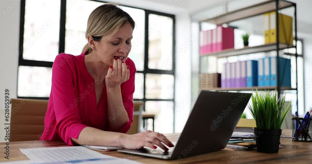Unhappy pensive woman looking at laptop screen biting nail working online. Stressed young business woman manager reading bad news in office workplace Unhappy pensive woman looking at laptop screen biting nail working online. Stressed young business woman manager reading bad news in office workplace