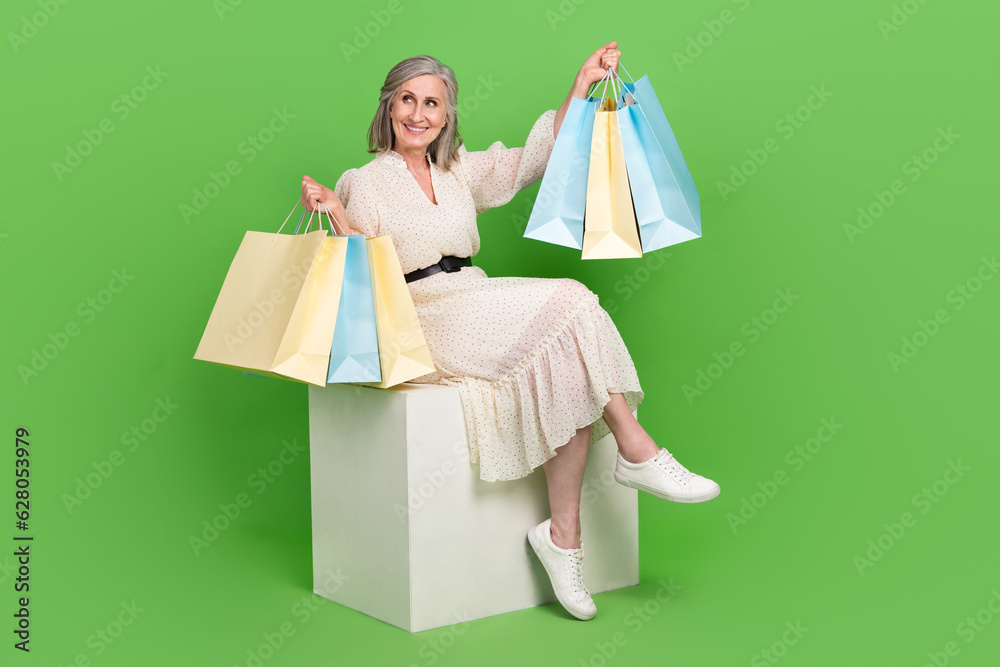 Full length photo of dreamy excited woman dressed beige outfit rising bargains empty space isolated green color background Full length photo of dreamy excited woman dressed beige outfit rising bargains empty space isolated green color background