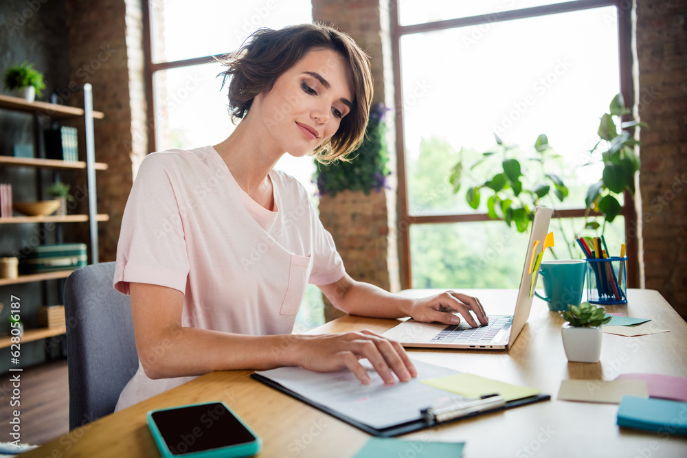 Fototapeta premium Photo of young woman brown bob hair first job dealer prepare contract for sale products browsing laptop isolated new office background