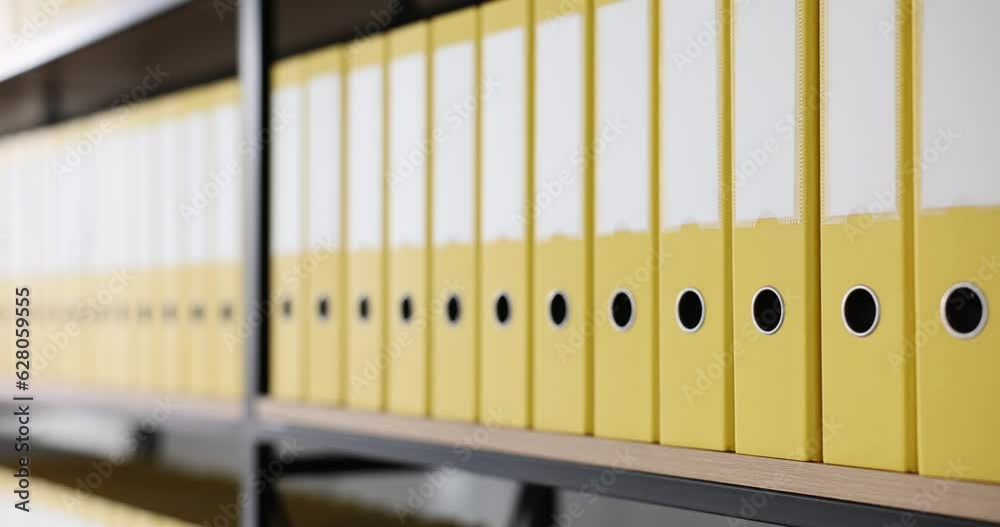Yellow folders with folders and documents on shelves. Organized folder structure and archive on counter in modern office