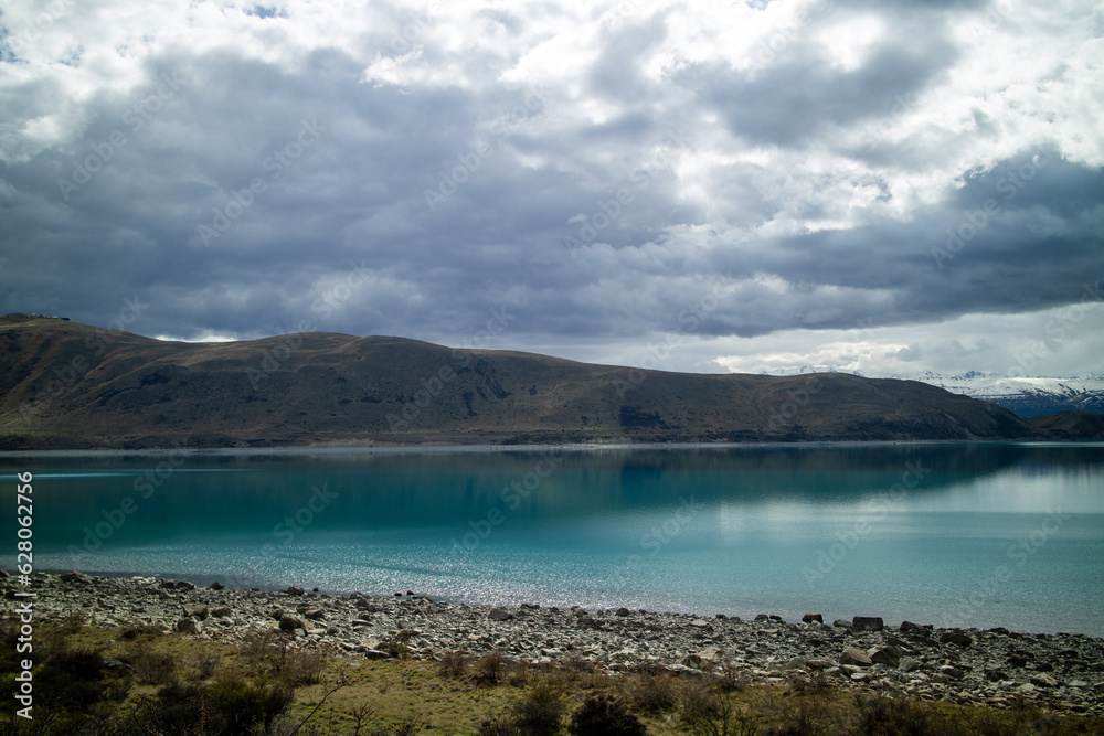 A green turqiose lake against a snow capped landscape. A green turqiose lake against a snow capped landscape.