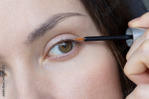 Cosmetic eyelash growth oil is applied to the eyelash growth line close-up. Eyelash treatment