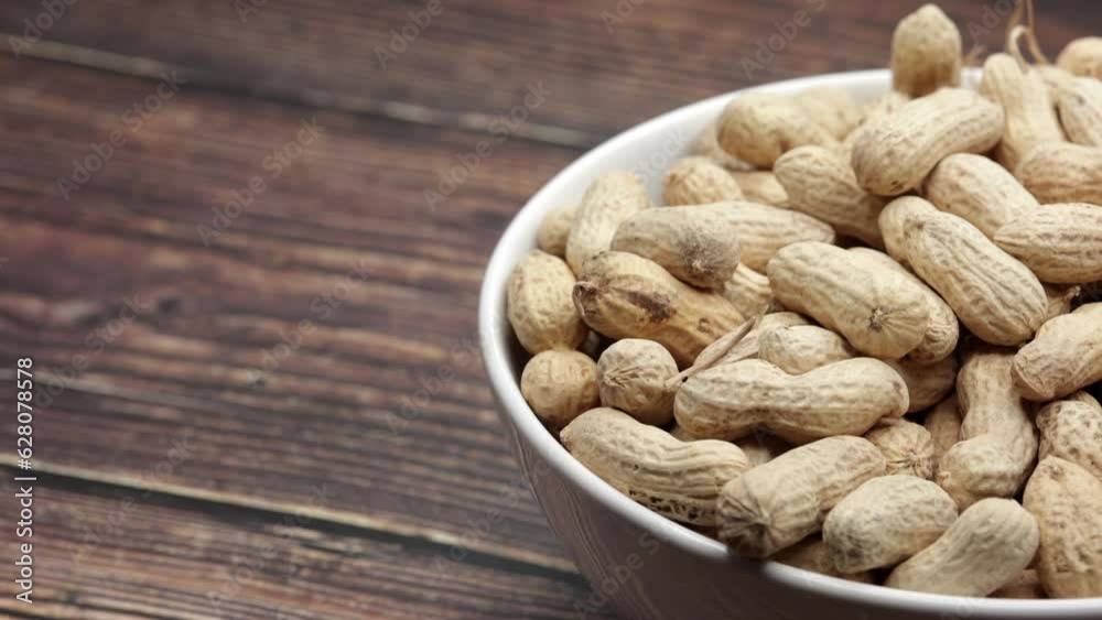 Raw Peanuts In White Bowl Cup On Wooden Board. Dolly Slider Shot. Raw Peanuts In White Bowl Cup On Wooden Board. Dolly Slider Shot.