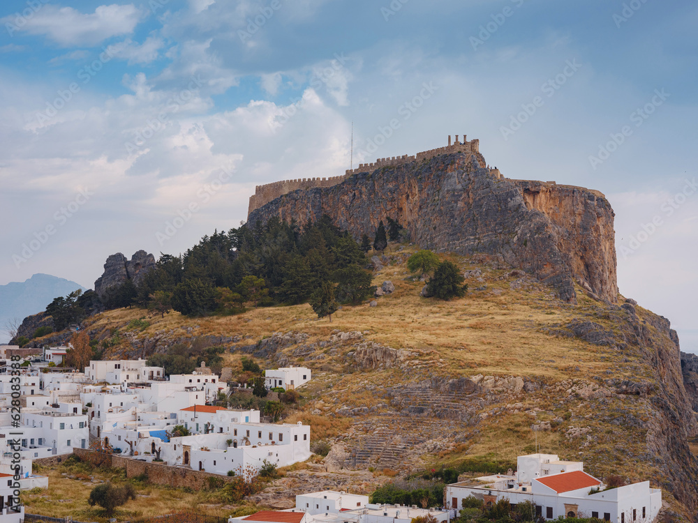 Fototapeta premium Lindos town in Greece aerial view in cloud summer day, white houses in Rhodes island , cityscape viewpoint traditional greek architecture, famous landmark and touristic destination concept