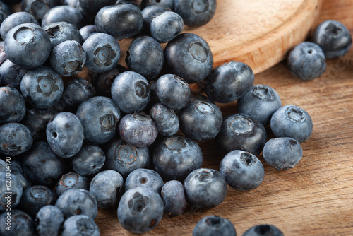 Blueberry. Fresh blueberries on a wooden surface close-up. Sprinkle blueberries. Scattered fresh blueberries. Organic food on a wooden table. Selective focus