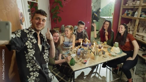 The master takes a group selfie after the master class. Group clay sculpting class in a ceramic workshop. High quality 4k footage