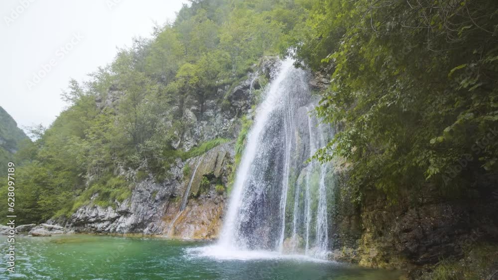 Waterfall on the mountain covered with green trees