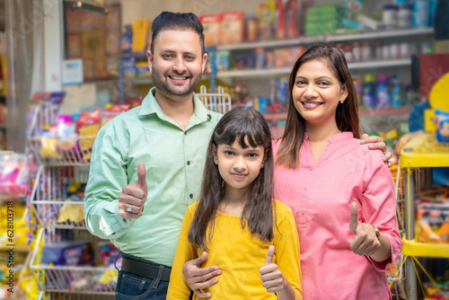 indian family showing thumps up at grocery shop.