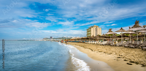 Golem, Durres, ALBANIA. Beach shoreline with sun umbrellas made from straw. A blue sky on the Adriatic Sea.