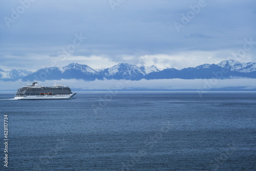 Breathtaking mountain glacier range view with luxury cruiseship cruise ship liner Orion sailing in front of Alaska mountains departure from Hoonah, Icy Strait Point with spectacular landscape scenery