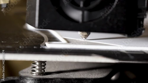 Closeup shot of a 3D printer printing a white object. laying molten fillament. photo