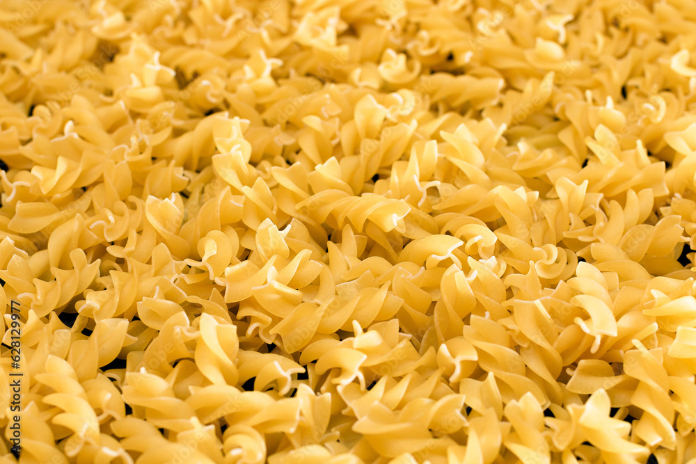 Uncooed Fusilli Pasta - Background. Texture of Bright Golden Dry Macaroni Uncooed Fusilli Pasta - Background. Texture of Bright Golden Dry Macaroni
