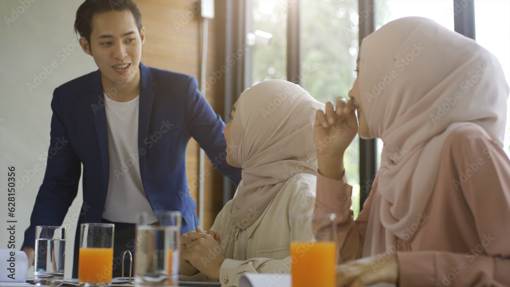 A group of successful upwardly mobile Asian Muslim friends relish a tranquil coffee shop gathering on a bright and joyful sunny day A group of successful upwardly mobile Asian Muslim friends relish a tranquil coffee shop gathering on a bright and joyful sunny day
