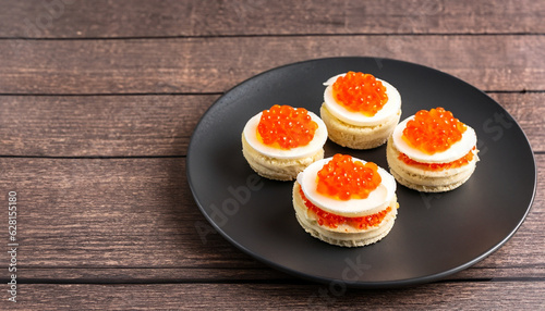 Caviar Sandwich on dark plate on wooden background with copy space