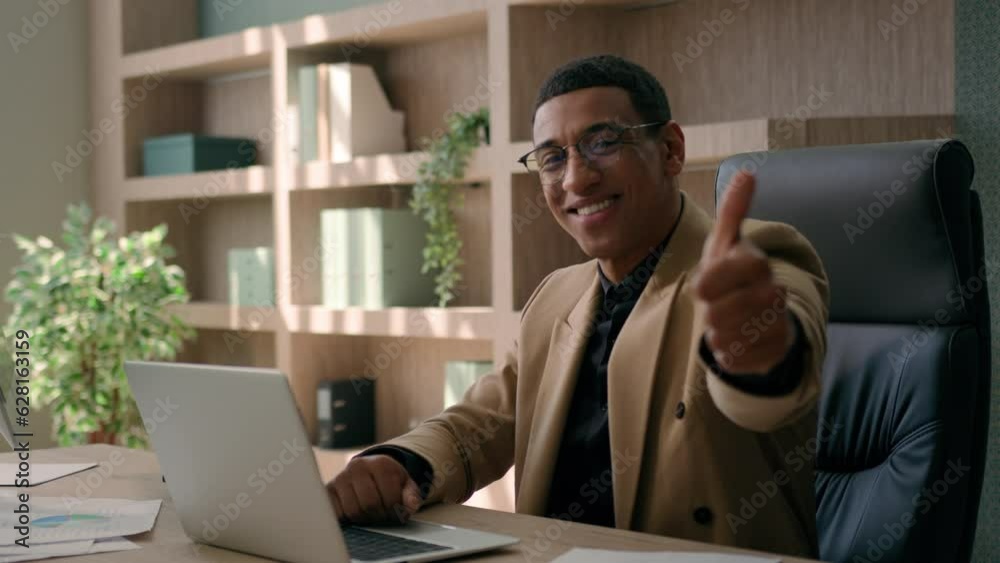 African American man happy glad businessman smiling entrepreneur office manager working laptop looking at camera smile show thumb up finger gesture recommend good business idea opportunity achievement African American man happy glad businessman smiling entrepreneur office manager working laptop looking at camera smile show thumb up finger gesture recommend good business idea opportunity achievement