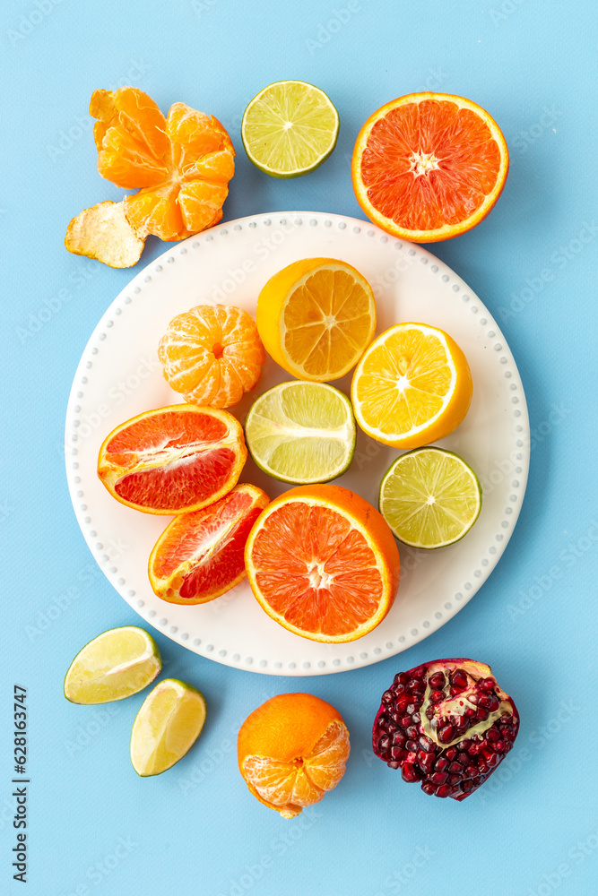 Layout of citrus fruits on white plate top view Layout of citrus fruits on white plate top view