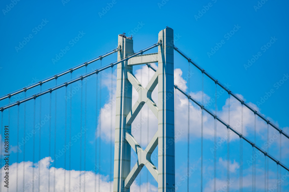 Fototapeta premium 明石海峡大橋の主塔の上部をクローズアップした写真。晴天を背景にとても美しい姿をしています。