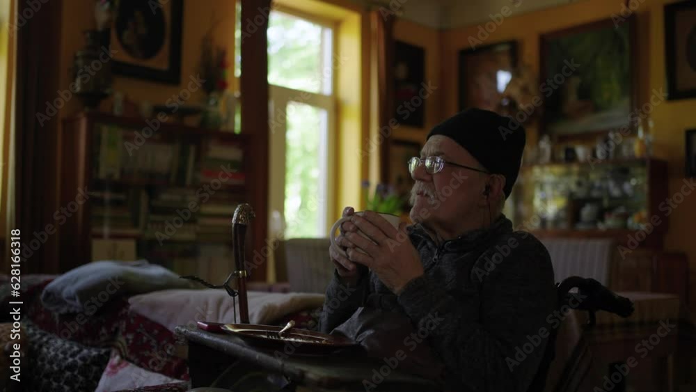 Old man in a wheelchair watching tv in the livingroom at home Old man in a wheelchair watching tv in the livingroom at home