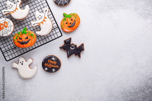Halloween gingerbread cookies on baking rack on stone background. Bright homemade cookies for Halloween party