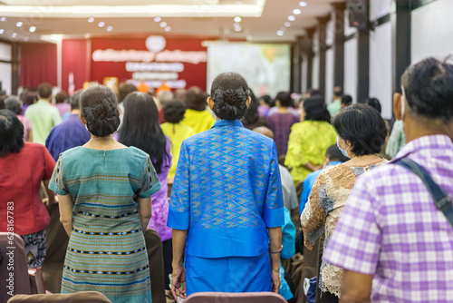 Back view of senior woman wear face mask attending and listening to the annual meeting in the auditorium. Asian elderly active participants in conference room. Joyful listeners of business conference. © JinnaritT