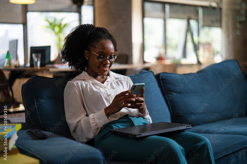Black businesswoman working on laptop. Portrait of beautiful businesswoman using the phone in the office.. Black businesswoman working on laptop. Portrait of beautiful businesswoman using the phone in the office..