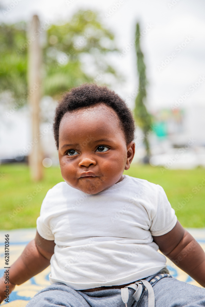 Portrait of an African baby outdoors in a park, vertical photo Portrait of an African baby outdoors in a park, vertical photo