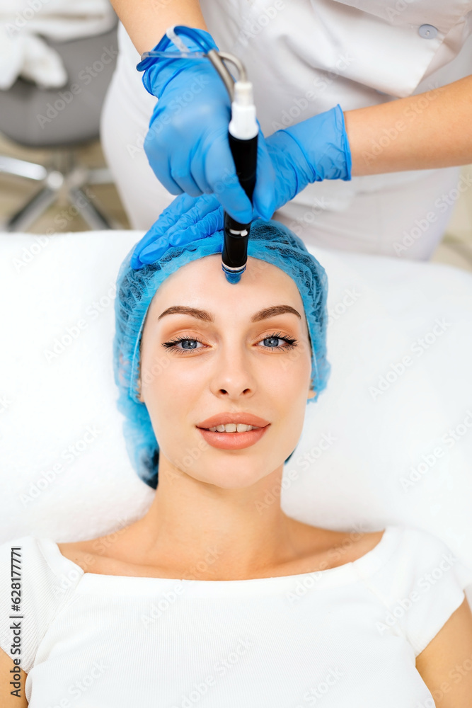Beautiful young woman enjoying a hydrafacial treatment at the beauty salon.