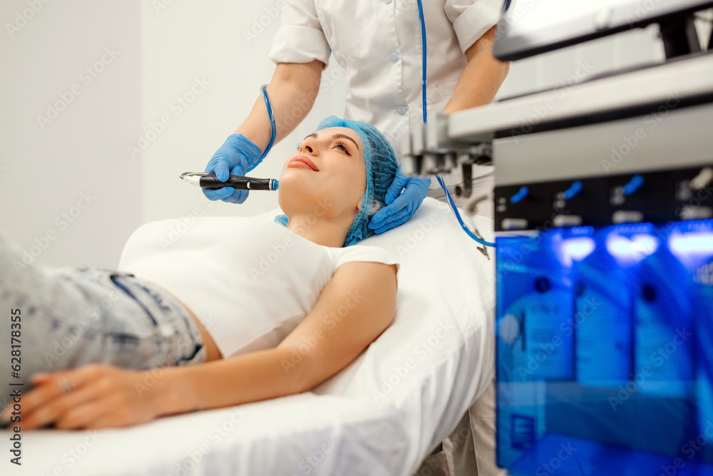 Facial skin care machine in spa clinic for anti-aging or acne treatment. The concept of aesthetic medicine, beauty tools, latest technologies in beauty industry. Facial skin care machine in spa clinic for anti-aging or acne treatment. The concept of aesthetic medicine, beauty tools, latest technologies in beauty industry.