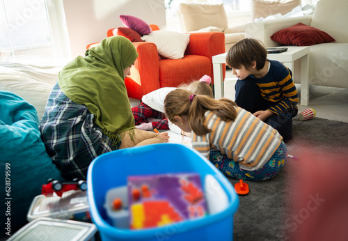 Muslim young teacher with small group of children having school learning