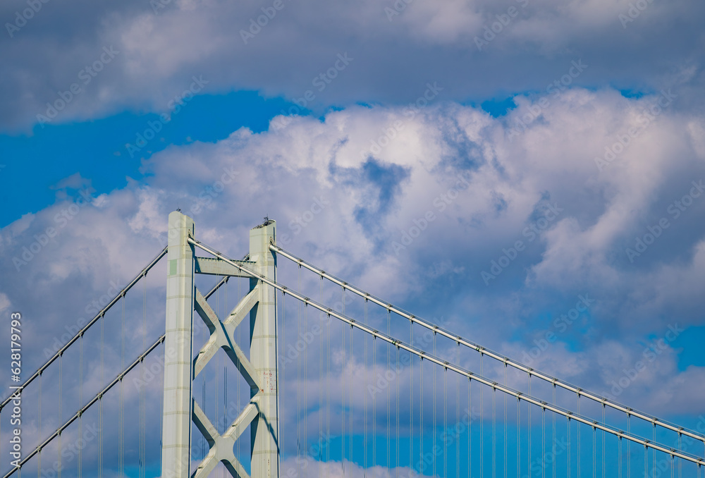 Fototapeta premium 明石海峡大橋の主塔の上部をクローズアップした写真。晴天を背景にとても美しい姿をしています。