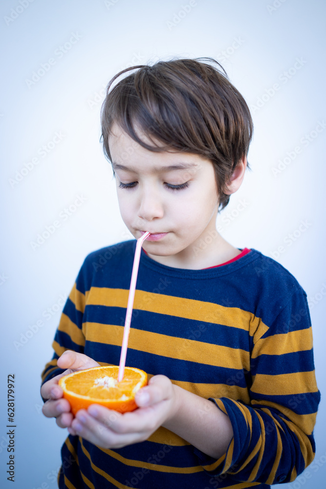 Little cute boy taking juice out of orange Little cute boy taking juice out of orange