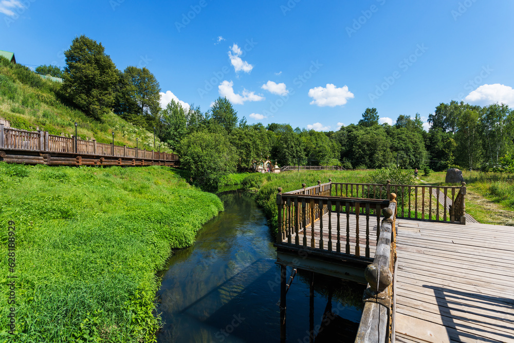 Wooden bridge across the river in the village. Russia, Moscow region