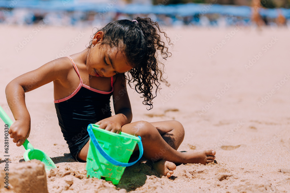 young girl playing in sand of beach on island of Tenerife Spain young girl playing in sand of beach on island of Tenerife Spain