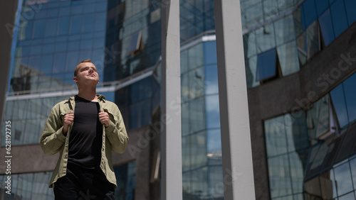 Wallpaper Mural A happy man in a khaki shirt stands in front of a skyscraper.  Torontodigital.ca