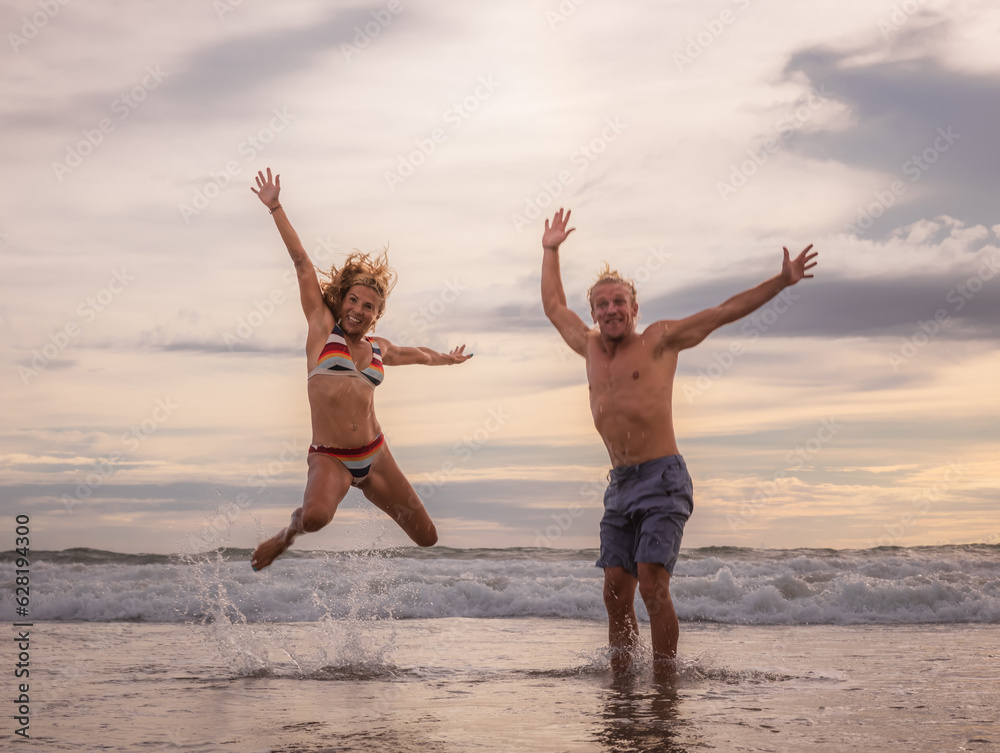 Happy family jumping on the beach. Motion movement of the body. Seminyak beach, Bali island, Indonesia Happy family jumping on the beach. Motion movement of the body. Seminyak beach, Bali island, Indonesia