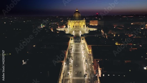 aerial view drone of rome vatican city saint peter basilica illuminated at night dusk,flying backwards over conciliazione street photo