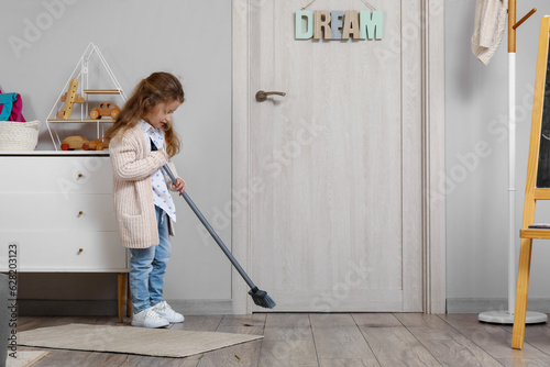 Cute little girl sweeping f...