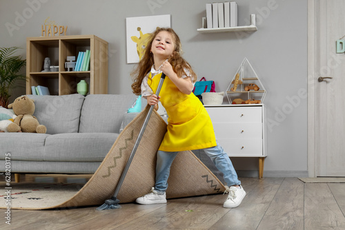 Cute little girl sweeping f...