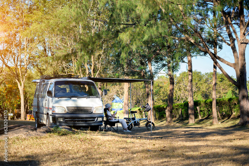 Asian woman travel and camping alone by camper van at park in Thailand. Recreation and journey outdoor activity lifestyle. © Sitthipong