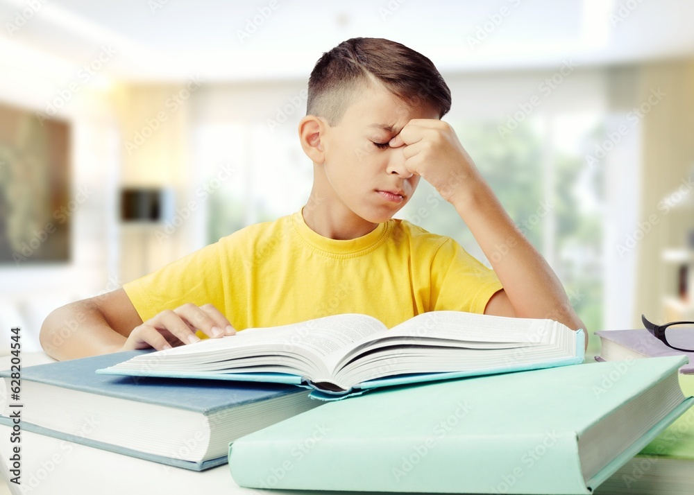 Back to school concept. Sad school kid studying at home Back to school concept. Sad school kid studying at home