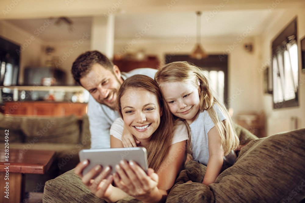 Fototapeta premium Young family taking a selfie on the couch in the living room