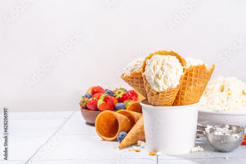 Cottage cheese ice cream, trendy white cottage cheese vanilla ice cream scoops in waffle cones, with fresh berries and toppings  photo