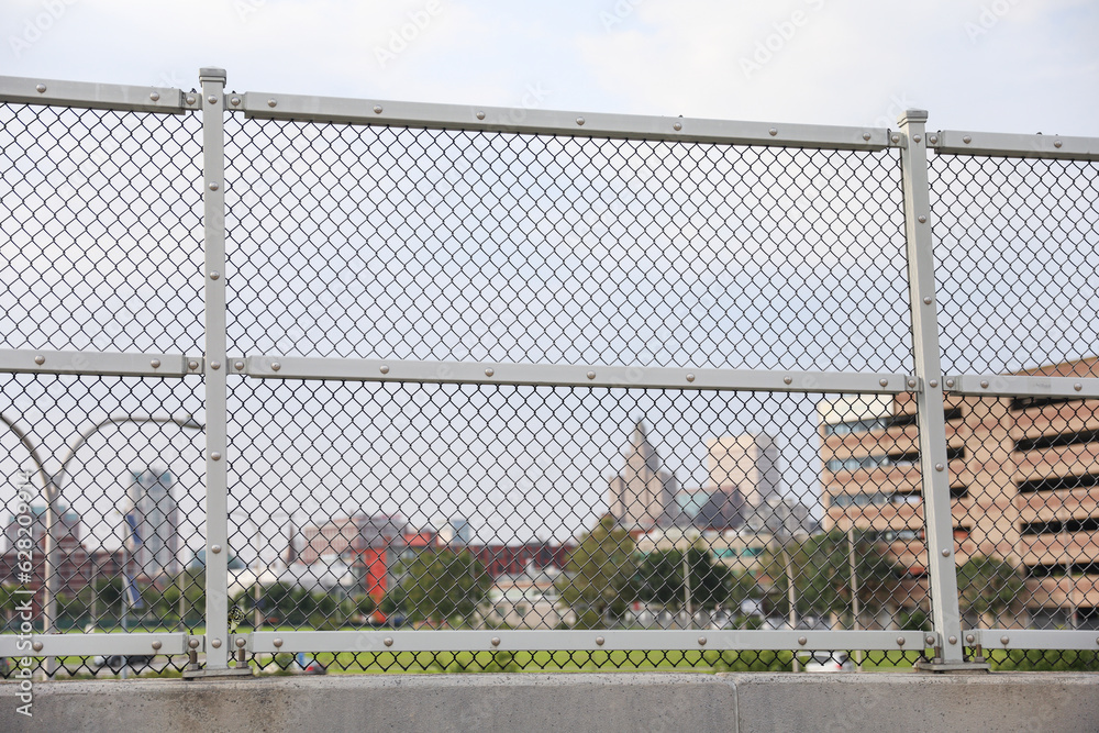 Chain-link fence symbolizes boundaries, security and isolation. Metaphor for protection and confinement. Concept of division and connection