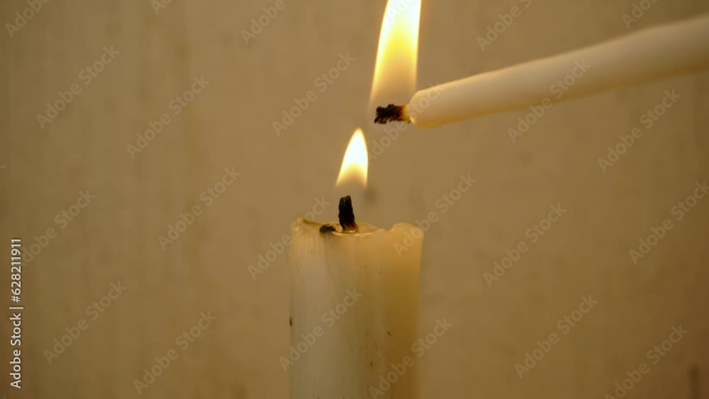 Encender vela blanca gruesa con otra vela blanca delegada en fondo claro horizontal 