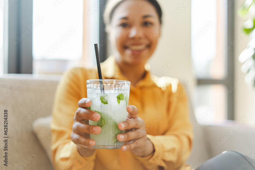 Portrait of smiling beautiful African American woman holding fresh tasty lemonade