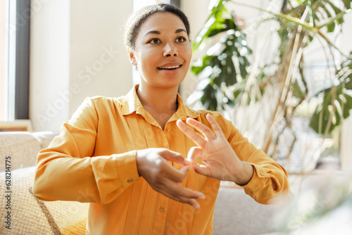 African American deaf sign language teacher communicating by hands gestures in modern office. Deafness concept  photo