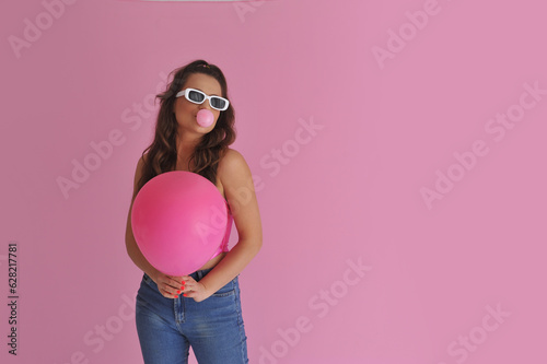 mulher com óculos retrô fazendo bolha com ciclete  photo