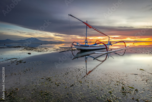 sunrise view and orange sky on the beach with traditional fishing boats